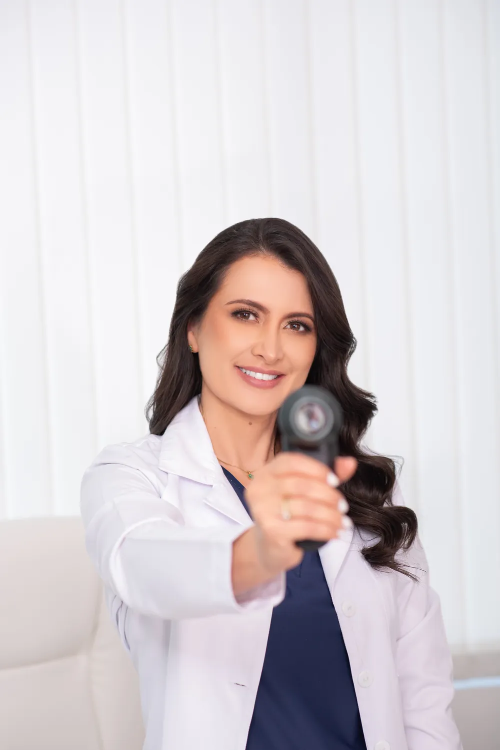La dermatóloga sostiene un dermatoscopio para revisar lunares